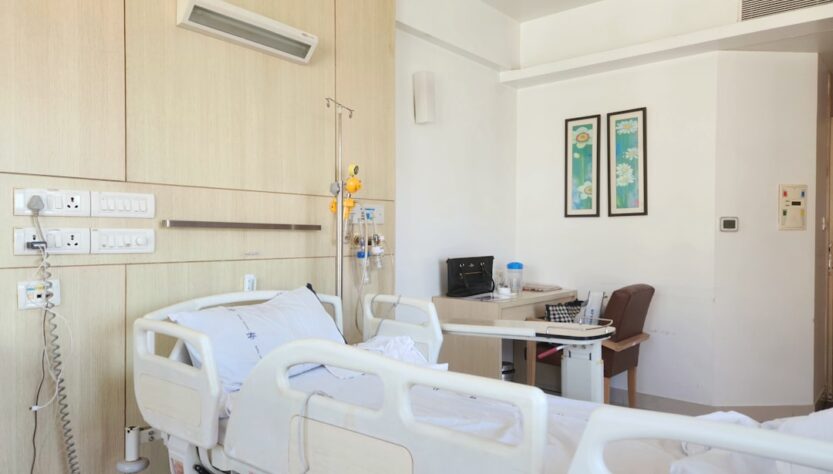 A hospital room with two empty beds and medical equipment visible